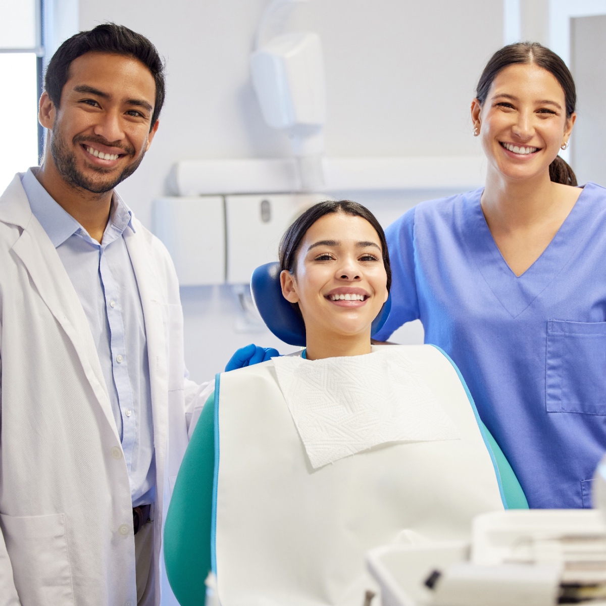 A happy dentist with his patient and assistant